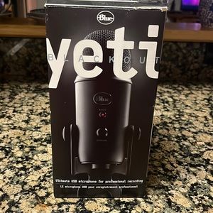 Yeti blue microphone with charger and foam pop filter.